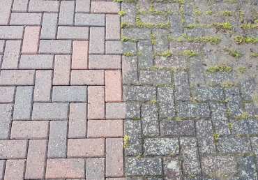 Power washing a driveway to remove dirt and stains